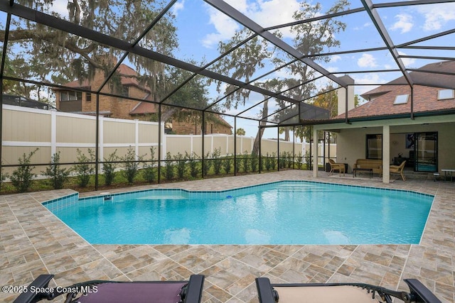 view of swimming pool with glass enclosure, outdoor lounge area, and a patio area