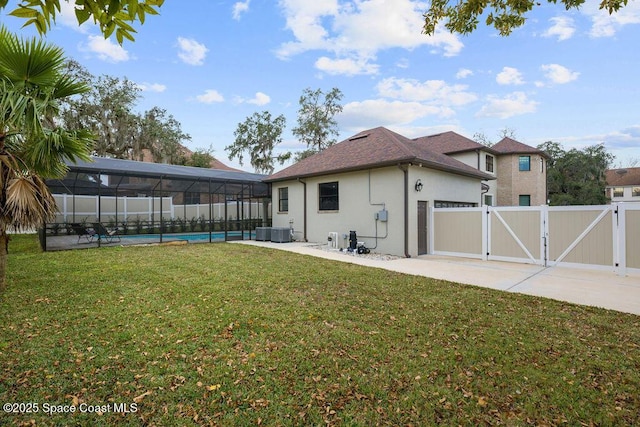 exterior space featuring central AC, a lawn, a lanai, and a fenced in pool