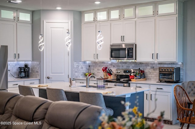 kitchen featuring appliances with stainless steel finishes, white cabinets, and light countertops