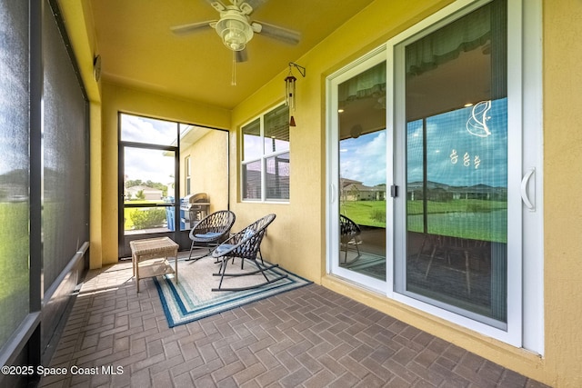 sunroom / solarium featuring a ceiling fan