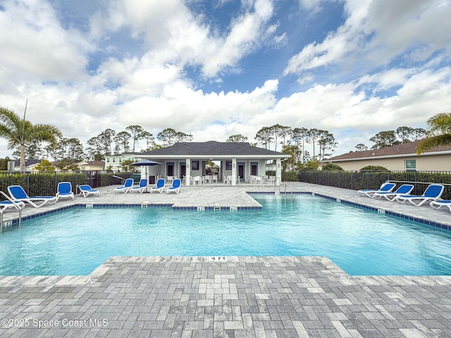 pool with a patio area and fence