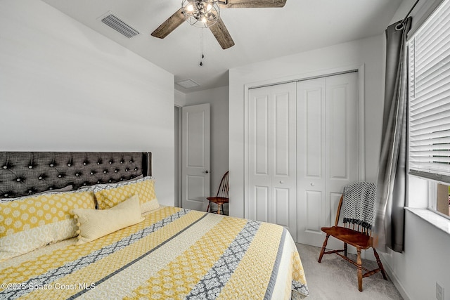 bedroom featuring baseboards, visible vents, light colored carpet, ceiling fan, and a closet