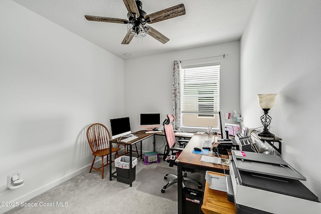 carpeted office with a ceiling fan and baseboards