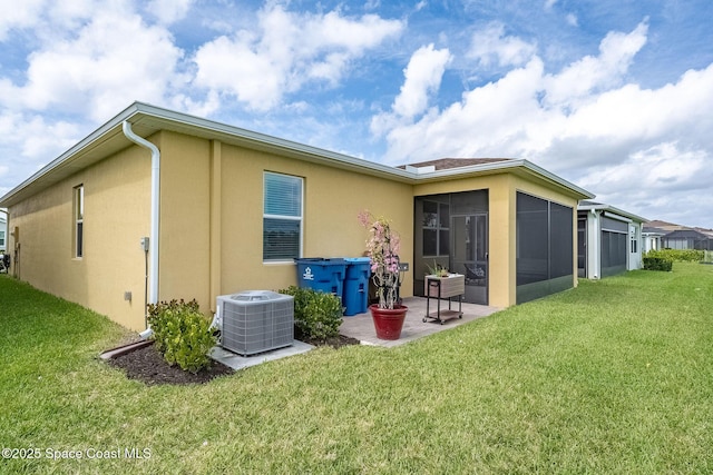 back of property with central AC unit, a lawn, a patio area, and stucco siding