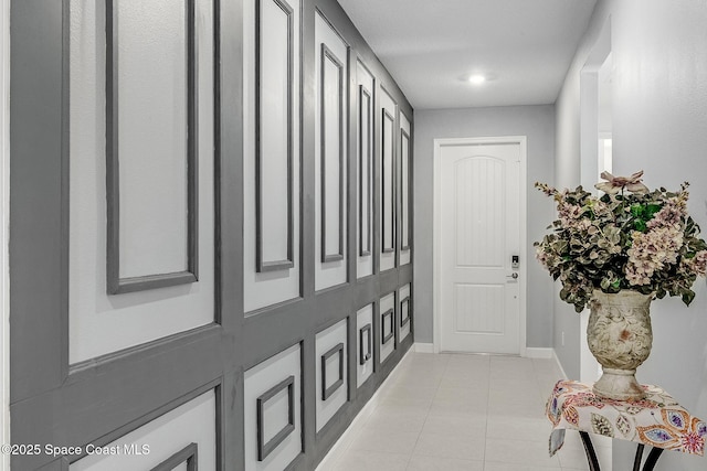 hallway with baseboards and light tile patterned flooring