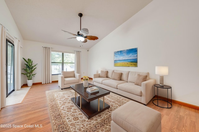 living area featuring vaulted ceiling, ceiling fan, light wood-style flooring, and baseboards