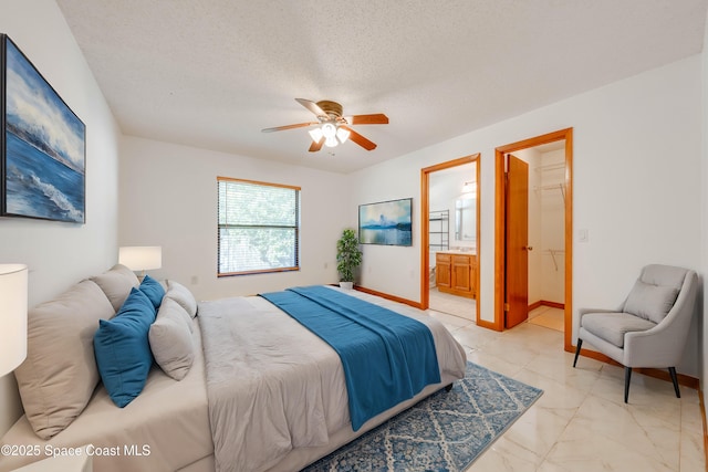 bedroom with a textured ceiling, ceiling fan, connected bathroom, baseboards, and marble finish floor