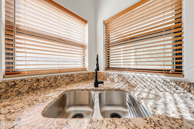 details featuring light stone counters and a sink