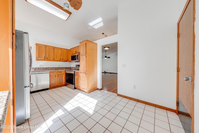 kitchen featuring ceiling fan, stainless steel appliances, light tile patterned flooring, and light countertops