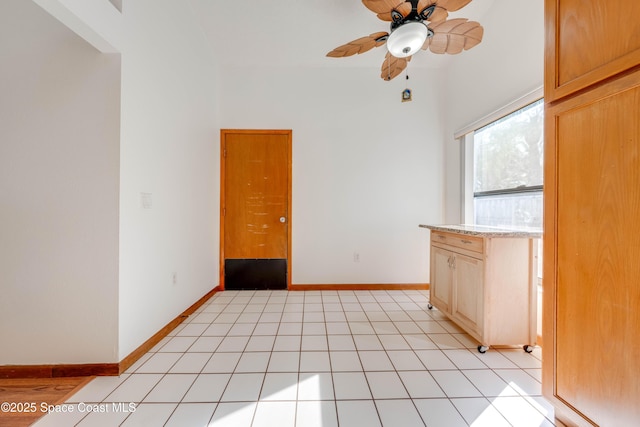 spare room featuring light tile patterned floors, baseboards, and a ceiling fan