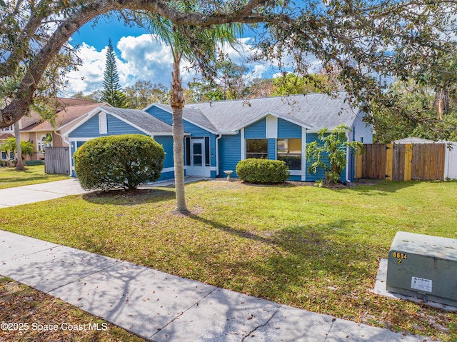 view of front of property with a front yard, driveway, and fence