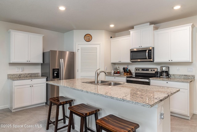 kitchen with white cabinetry, sink, a kitchen island with sink, and appliances with stainless steel finishes