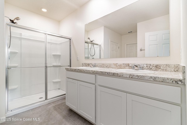 bathroom with tile patterned flooring, vanity, and a shower with shower door