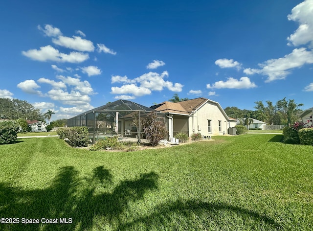 back of house with a yard and a lanai