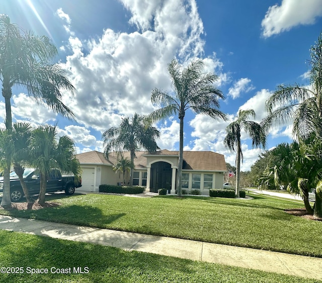 single story home featuring a garage and a front yard