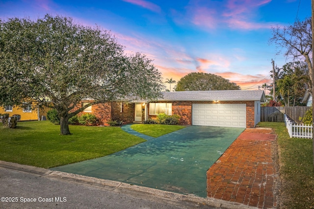 ranch-style home with a garage and a lawn