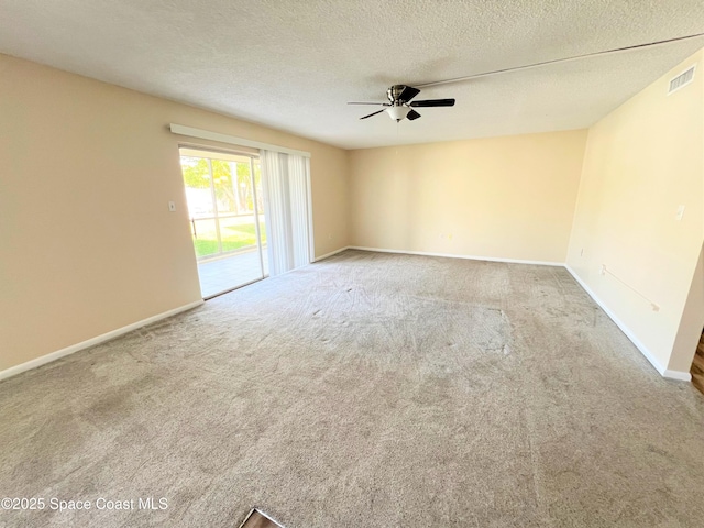 carpeted empty room with a textured ceiling, ceiling fan, visible vents, and baseboards