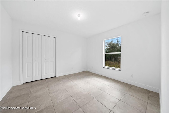 unfurnished bedroom featuring a closet and light tile patterned flooring