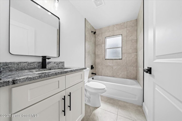 full bathroom featuring vanity, tile patterned floors, toilet, and tiled shower / bath