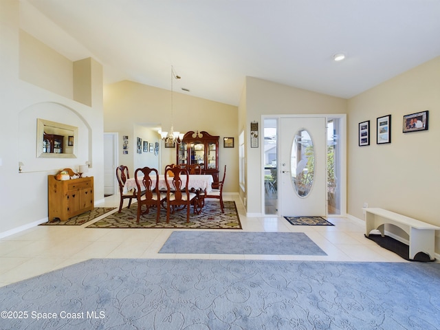 tiled entryway with lofted ceiling and a notable chandelier