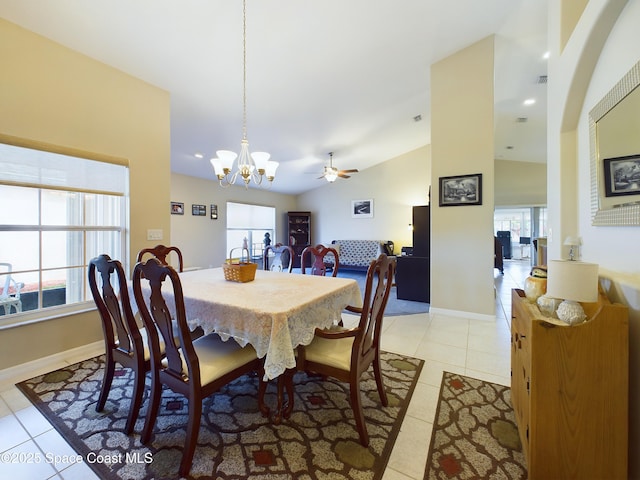 dining room featuring lofted ceiling, light tile patterned floors, a healthy amount of sunlight, and an inviting chandelier