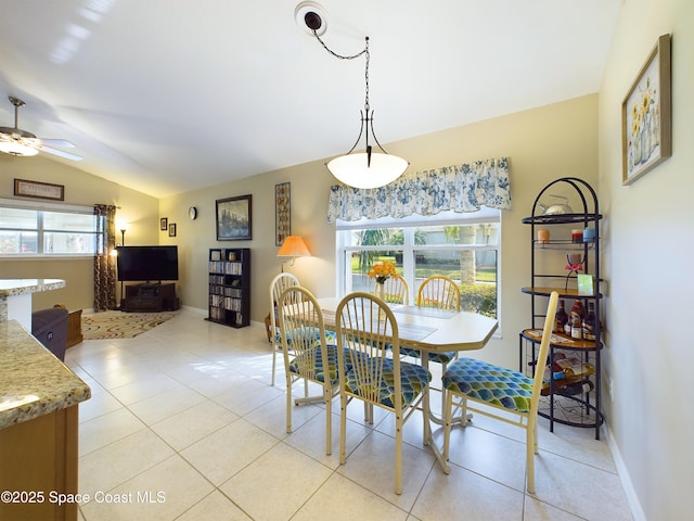 tiled dining area featuring lofted ceiling and ceiling fan