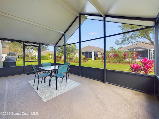 sunroom / solarium featuring lofted ceiling with beams