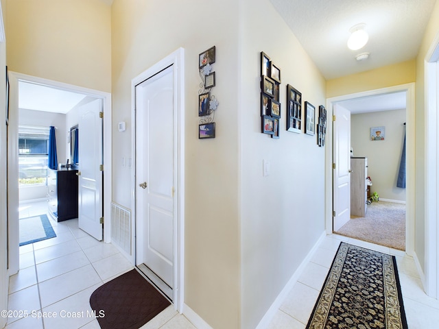 hall featuring light tile patterned floors