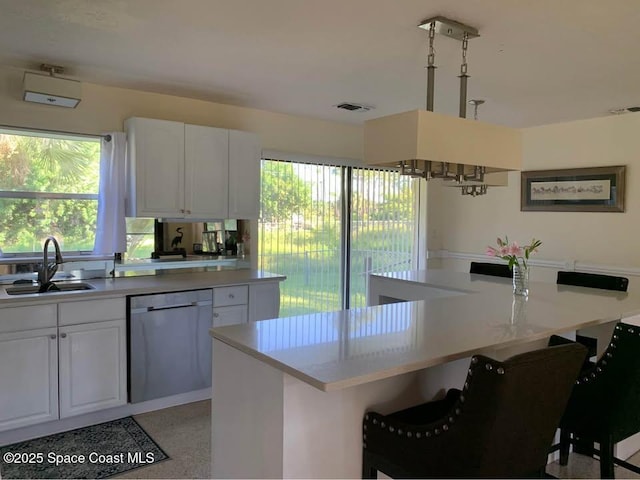 kitchen with a kitchen island, a breakfast bar, sink, white cabinets, and stainless steel dishwasher