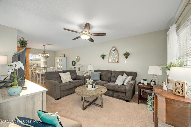 828 Parkwood Ave, Titusville, FL 32796 - living area featuring light colored carpet, a ceiling fan, and a chandelier