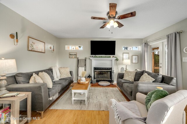 828 Parkwood Ave, Titusville, FL 32796 - living room with light wood-type flooring, ceiling fan, and a glass covered fireplace