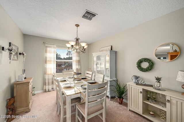 828 Parkwood Ave, Titusville, FL 32796 - dining space with light carpet, a chandelier, a textured ceiling, and baseboards