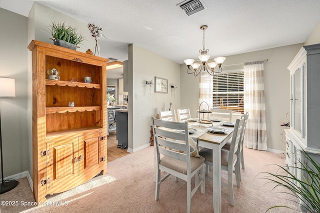828 Parkwood Ave, Titusville, FL 32796 - dining room featuring light colored carpet, a chandelier, baseboards, and a textured ceiling