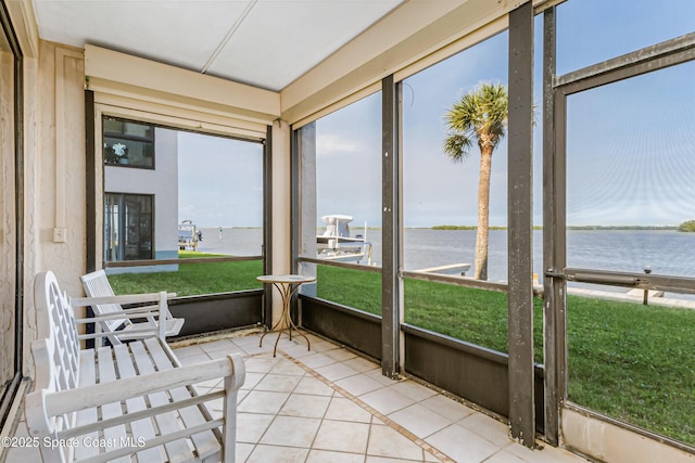 sunroom featuring a water view