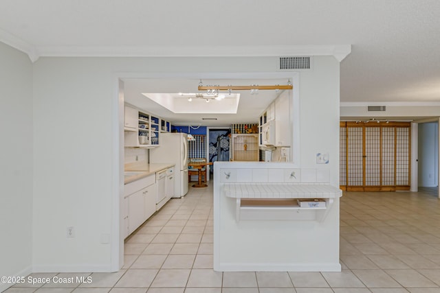 kitchen with light tile patterned floors, white appliances, ornamental molding, white cabinets, and a chandelier