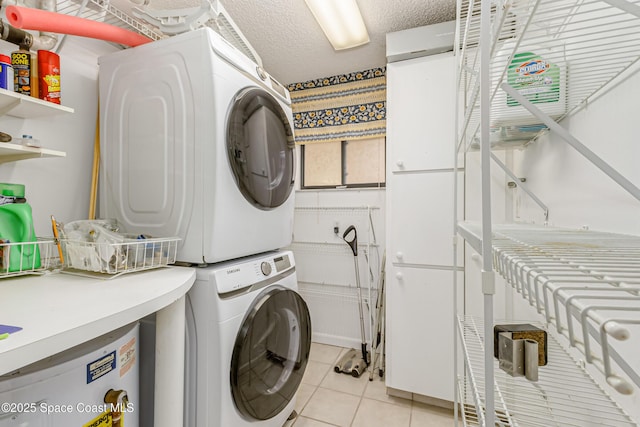 washroom featuring stacked washer / drying machine, light tile patterned floors, and a textured ceiling