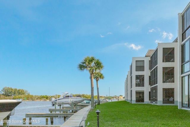 dock area featuring a lawn and a water view