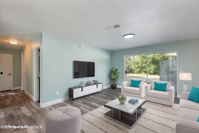 living room with wood-type flooring and a textured ceiling