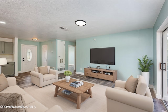 living room featuring light hardwood / wood-style flooring and a textured ceiling