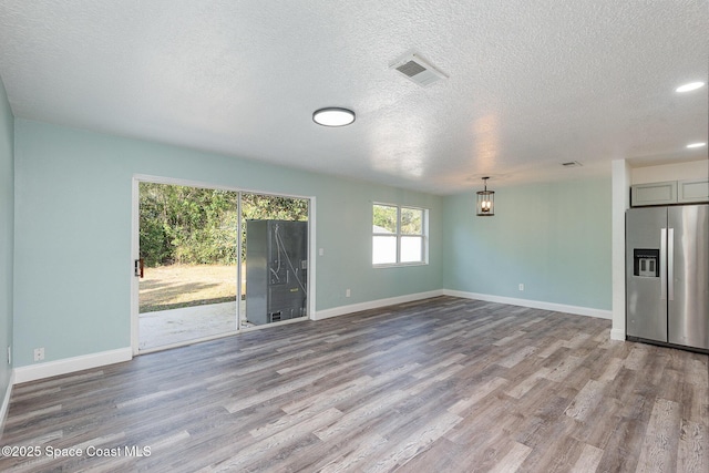 unfurnished living room featuring a textured ceiling and light wood-type flooring