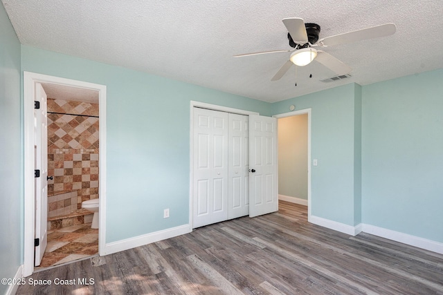 unfurnished bedroom with ensuite bathroom, hardwood / wood-style floors, ceiling fan, a textured ceiling, and a closet