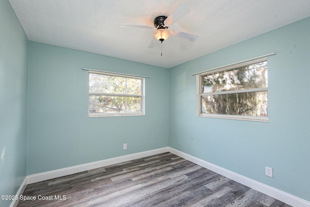 empty room featuring ceiling fan, a textured ceiling, and dark hardwood / wood-style flooring