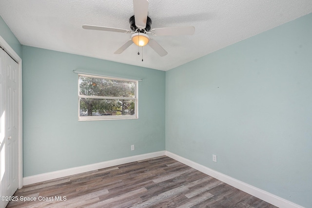 empty room featuring ceiling fan, hardwood / wood-style flooring, and a textured ceiling