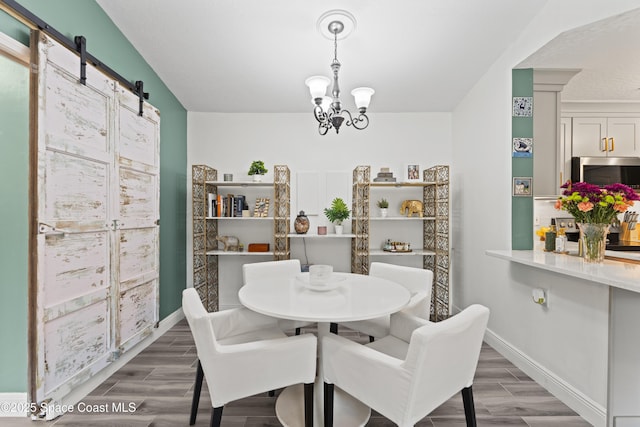 dining room with a barn door and a chandelier