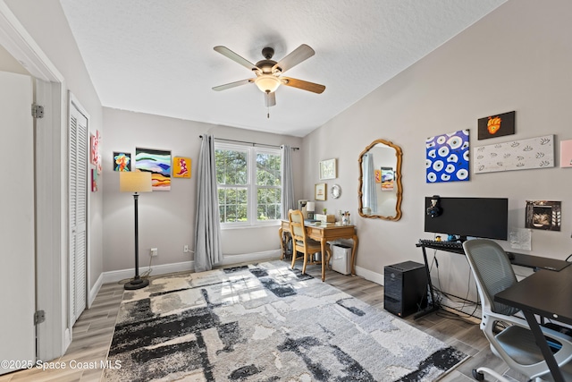 home office with a textured ceiling, wood-type flooring, and ceiling fan