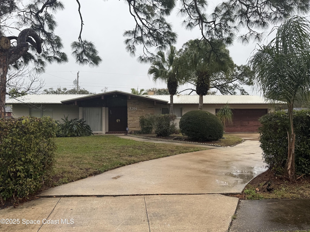 view of front of home featuring driveway, an attached garage, and a front yard