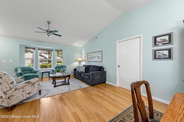 living room with hardwood / wood-style flooring, high vaulted ceiling, and ceiling fan