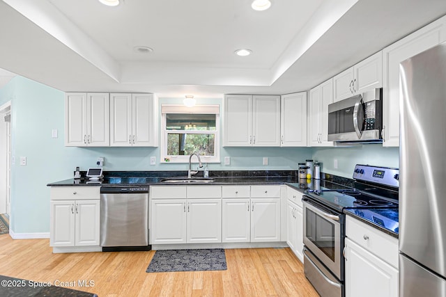 kitchen featuring sink, stainless steel appliances, a raised ceiling, and white cabinets