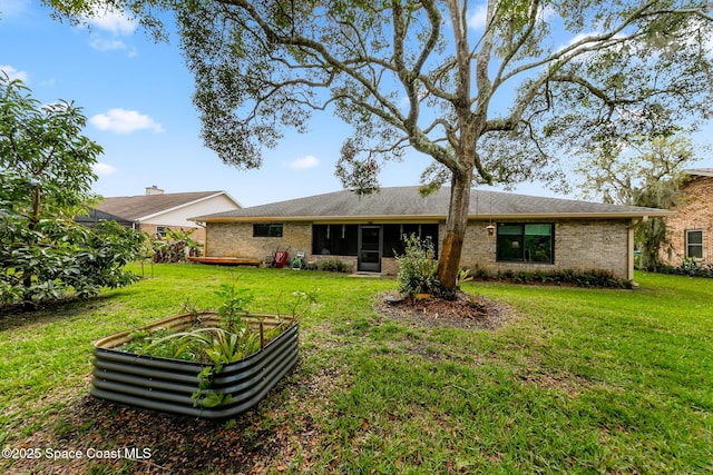 rear view of house featuring a lawn