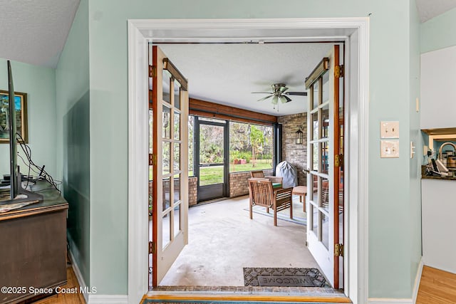 sunroom featuring ceiling fan and french doors